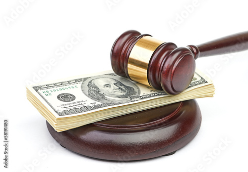 Photo: Law gavel on a stack of American money. Law gavel on a stack of American money.