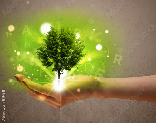 Photo: Glowing tree growing in the hand of a woman Glowing tree growing in the hand of a woman
