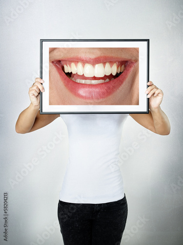 Photo: Woman holding picture with a big smile Woman holding picture with a big smile