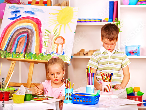Photo: Child painting at easel. Child painting at easel.