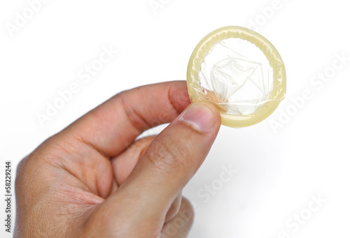 Photo: hand holding a condom hand holding a condom