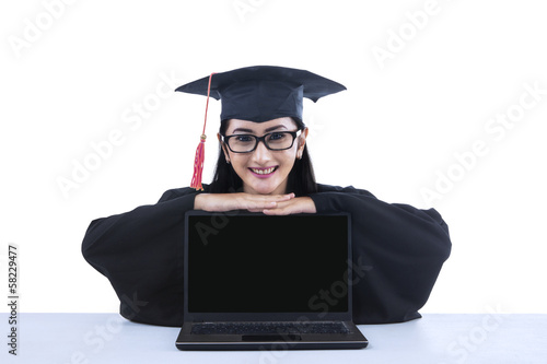 Photo: Asian graduate with blank screen laptop Asian graduate with blank screen laptop