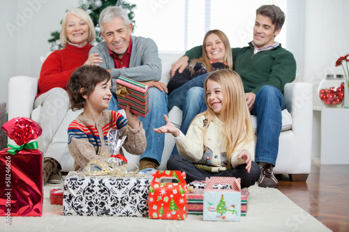 Photo: Family With Christmas Presents At Home Family With Christmas Presents At Home
