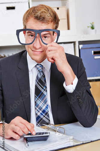Photo: Business man holding nerd glasses in office Business man holding nerd glasses in office