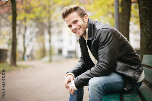 Photo: lächelnder Mann auf Parkbank lächelnder Mann auf Parkbank