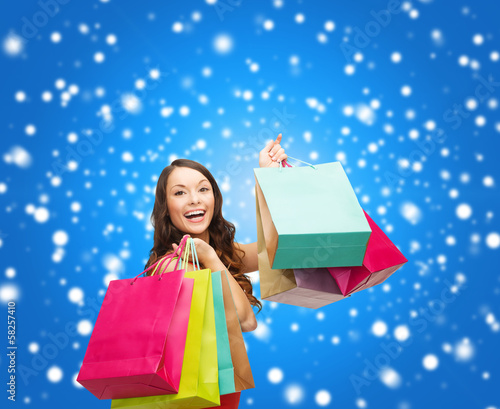 Photo: woman in red dress with colorful shopping bags woman in red dress with colorful shopping bags