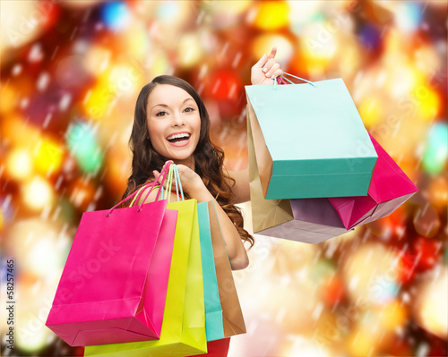 Photo: woman in red dress with colorful shopping bags woman in red dress with colorful shopping bags