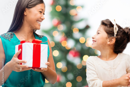 Photo: happy mother and child girl with gift box happy mother and child girl with gift box