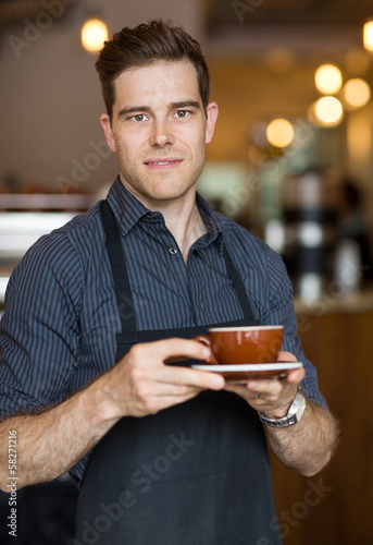 Photo: Barista Standing in Cafe with Cup Barista Standing in Cafe with Cup