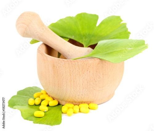 Photo: Ginkgo biloba leaves in mortar and pills isolated on white Ginkgo biloba leaves in mortar and pills isolated on white
