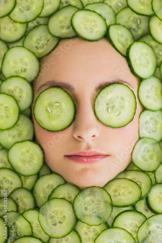 Photo: Beautiful woman with facial mask of cucumber slices on face Beautiful woman with facial mask of cucumber slices on face