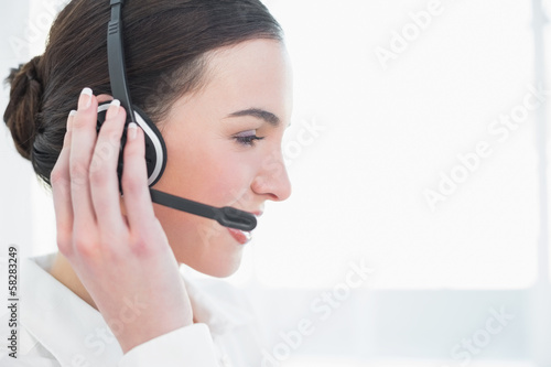 Photo: Close up side view of businesswoman wearing headset Close up side view of businesswoman wearing headset
