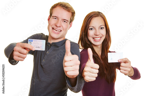 Photo: Man and woman with drivers licence holding thumbs up Man and woman with drivers licence holding thumbs up