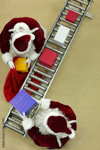 Photo: santa clauses working at conveyor belt in Christmas factory santa clauses working at conveyor belt in Christmas factory