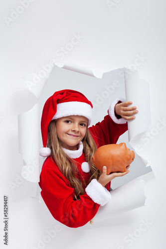 Photo: Little santa girl saving for christmas presents Little santa girl saving for christmas presents