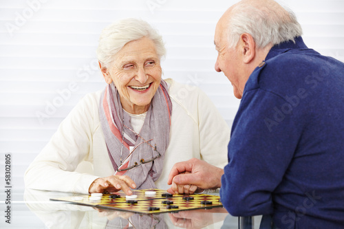 Photo: Seniorenpaar spielt Dame im Seniorenheim Seniorenpaar spielt Dame im Seniorenheim