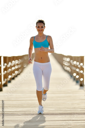 Photo: young woman jogging on the beach young woman jogging on the beach