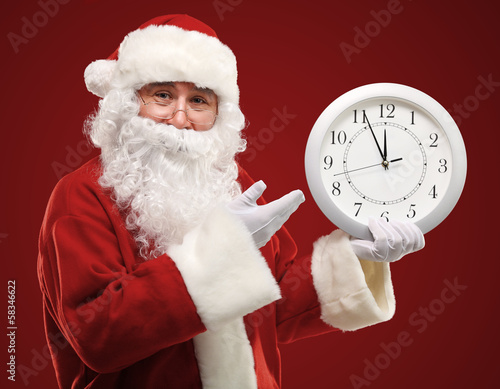 Photo: Santa pointing at clock showing five minutes to midnight Santa pointing at clock showing five minutes to midnight
