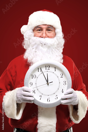 Photo: Santa pointing at clock showing five minutes to midnight Santa pointing at clock showing five minutes to midnight