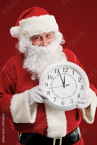 Photo: Stunned Santa holding clock showing five minutes to midnight Stunned Santa holding clock showing five minutes to midnight