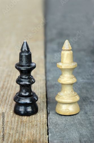 Photo: Chess queen figures on a contrast wooden background Chess queen figures on a contrast wooden background