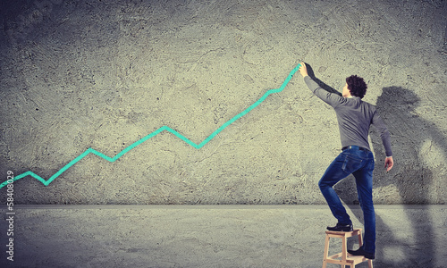 Photo: Young man drawing a graph on the wall Young man drawing a graph on the wall