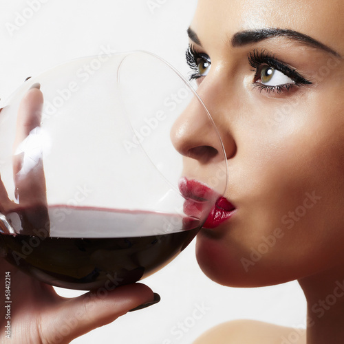 Photo: Beautiful blond woman drinking red wine.make-up.red lips Beautiful blond woman drinking red wine.make-up.red lips