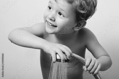 Photo: smiling little boy in the shower.Bath.child.monochrome smiling little boy in the shower.Bath.child.monochrome