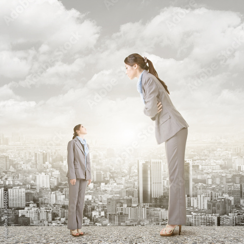 Photo: Businesswoman looking on her big version on the roof Businesswoman looking on her big version on the roof