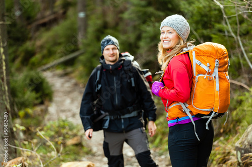 Photo: Couple happy hikers walking in mountains Couple happy hikers walking in mountains