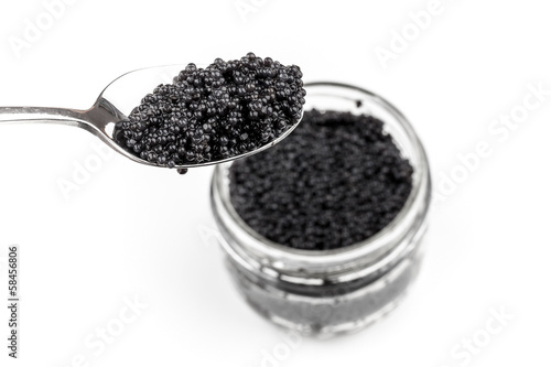 Photo: Black caviar in full glass jar and teaspoon isolated on white ba Black caviar in full glass jar and teaspoon isolated on white ba