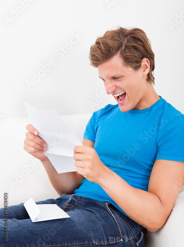 Photo: Happy Man Looking At Paper Happy Man Looking At Paper