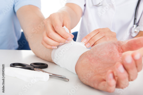 Photo: Doctor Bandaging Patient Doctor Bandaging Patient