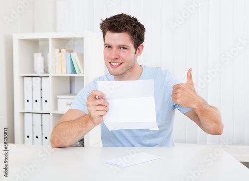 Photo: Happy Man Looking At Paper Happy Man Looking At Paper