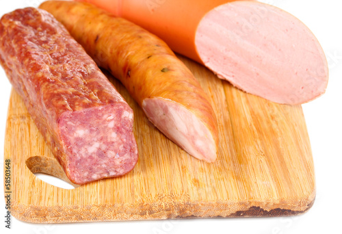 Photo: Tasty sausage on chopping board close-up Tasty sausage on chopping board close-up