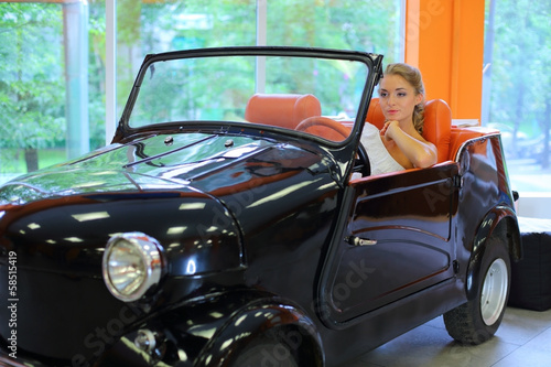 Photo: A pretty woman driving a retro black car A pretty woman driving a retro black car