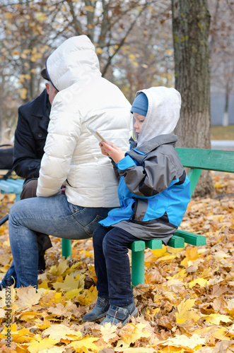 Photo: Cute little boy reading his tablet-pc Cute little boy reading his tablet-pc