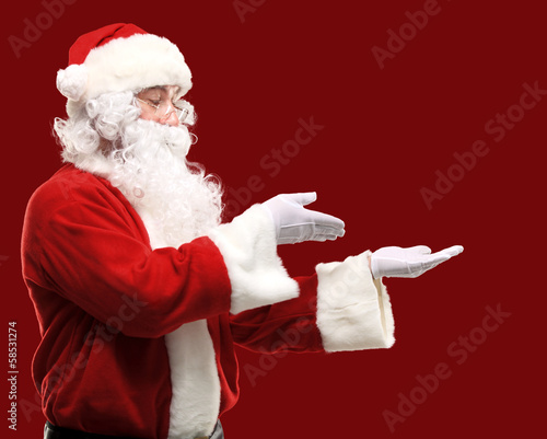 Photo: Santa Claus with his arms out in a presenting gesture Santa Claus with his arms out in a presenting gesture