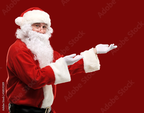Photo: Santa Claus with his arms out in a presenting gesture Santa Claus with his arms out in a presenting gesture