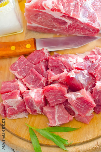 Photo: raw meat and knife on the wooden board raw meat and knife on the wooden board
