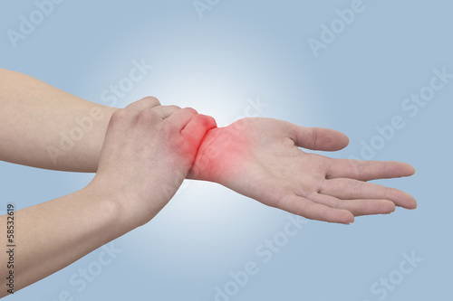Photo: Acute pain in a woman wrist. Female holding hand to spot of wris Acute pain in a woman wrist. Female holding hand to spot of wris