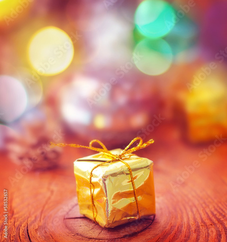Photo: Gold present and cristmas decoration on the wooden board Gold present and cristmas decoration on the wooden board