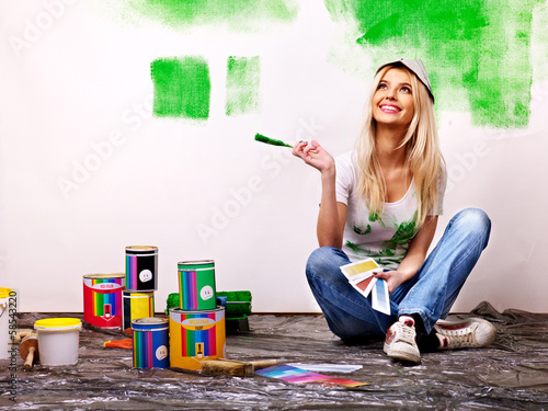 Photo: Woman paint wall at home. Woman paint wall at home.