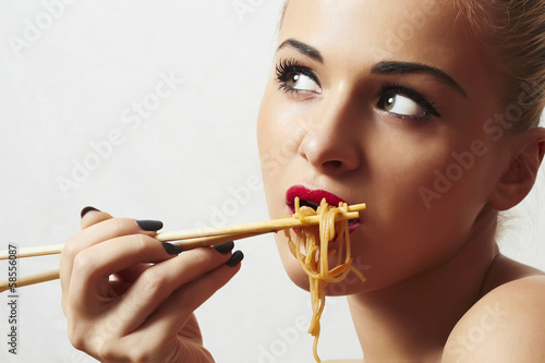 Photo: Beautiful woman eating chinese food. wok. noodles Beautiful woman eating chinese food. wok. noodles
