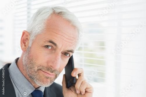 Photo: Close-up of a serious mature businessman using cellphone Close-up of a serious mature businessman using cellphone