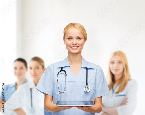Photo: smiling female doctor or nurse with tablet pc smiling female doctor or nurse with tablet pc