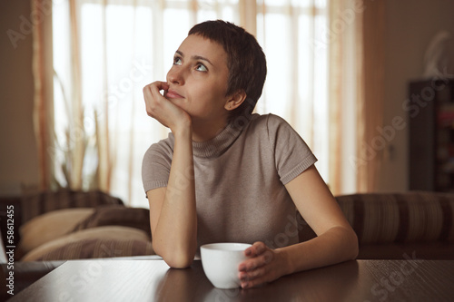 Photo: Dreamy girl sitting with a cup of coffee Dreamy girl sitting with a cup of coffee