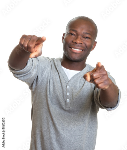 Photo: Laughing african man pointing with two fingers at camera Laughing african man pointing with two fingers at camera