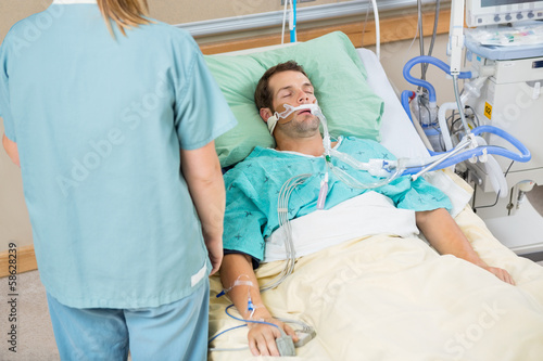 Photo: Patient Sleeping With Nurse Standing By Patient Sleeping With Nurse Standing By