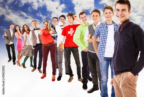 Photo: Large group of multicolored dressed teenagers on blue sky Large group of multicolored dressed teenagers on blue sky